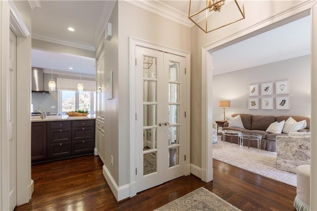 hall featuring dark wood finished floors, a sink, recessed lighting, and ornamental molding