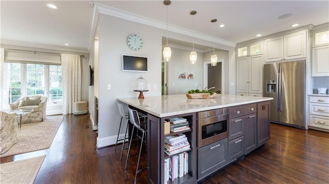 kitchen featuring built in microwave, glass insert cabinets, stainless steel refrigerator with ice dispenser, white cabinetry, and a kitchen breakfast bar