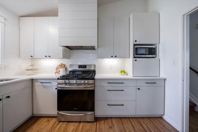 kitchen with light wood-style flooring, stainless steel appliances, and light countertops