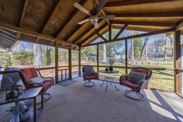 sunroom / solarium with lofted ceiling with beams, wood ceiling, and a ceiling fan