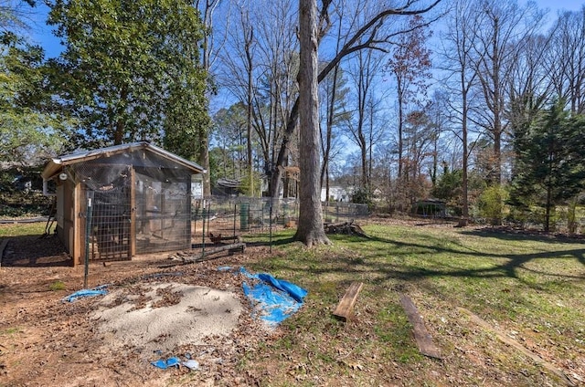 view of yard featuring exterior structure, fence, and an outbuilding