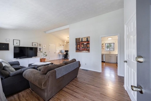 living area featuring lofted ceiling with beams, a notable chandelier, dark wood-type flooring, visible vents, and baseboards