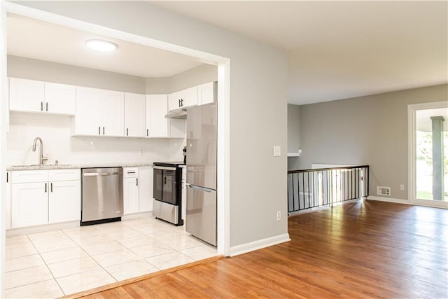 4339 Sasanqua Ct, Tucker, GA 30084 - kitchen featuring stainless steel appliances, a sink, light wood-style floors, white cabinetry, and baseboards