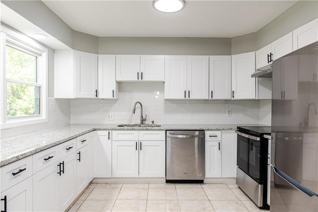 4339 Sasanqua Ct, Tucker, GA 30084 - kitchen featuring appliances with stainless steel finishes, a sink, under cabinet range hood, white cabinets, and backsplash