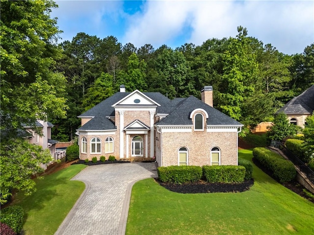 8370 Royal Melbourne Way, Duluth, GA 30097 - greek revival house with a chimney, brick siding, and a front lawn