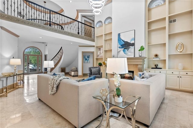 8370 Royal Melbourne Way, Duluth, GA 30097 - living room with a high ceiling, built in shelves, stairway, a premium fireplace, and light marble finish floors