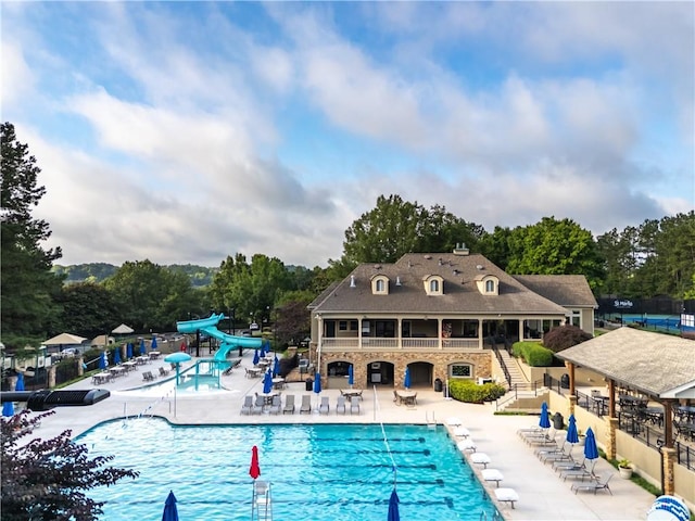 8370 Royal Melbourne Way, Duluth, GA 30097 - community pool featuring a water slide, stairs, a patio, and view of scattered trees