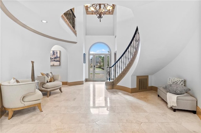 8370 Royal Melbourne Way, Duluth, GA 30097 - foyer with arched walkways, a chandelier, stairway, and a towering ceiling