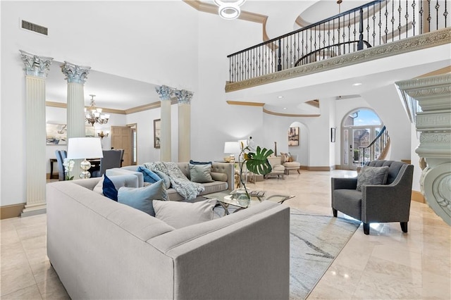 8370 Royal Melbourne Way, Duluth, GA 30097 - living room featuring a chandelier, a high ceiling, crown molding, decorative columns, and stairs
