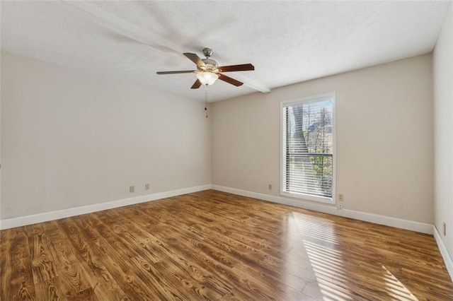 unfurnished room with a ceiling fan, a textured ceiling, baseboards, and wood finished floors