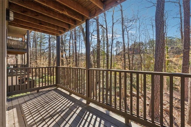 wooden terrace featuring a view of trees