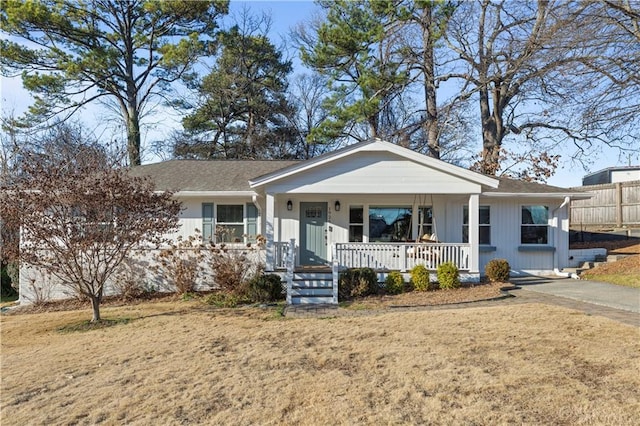 single story home with a porch and fence