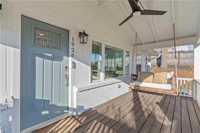 wooden terrace with a ceiling fan and fence