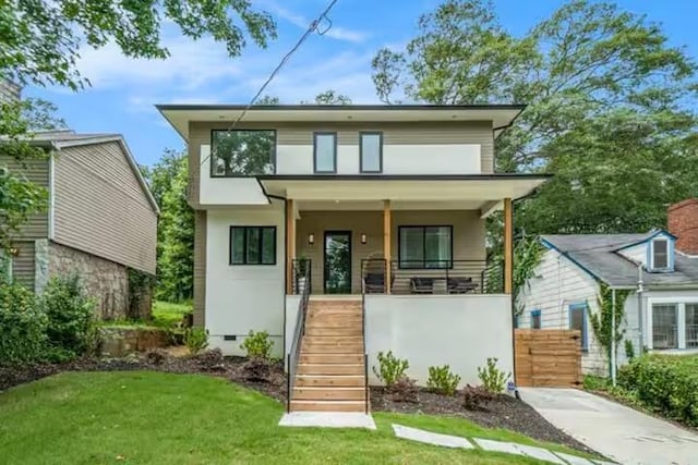 modern home with crawl space, covered porch, a front yard, and stairway