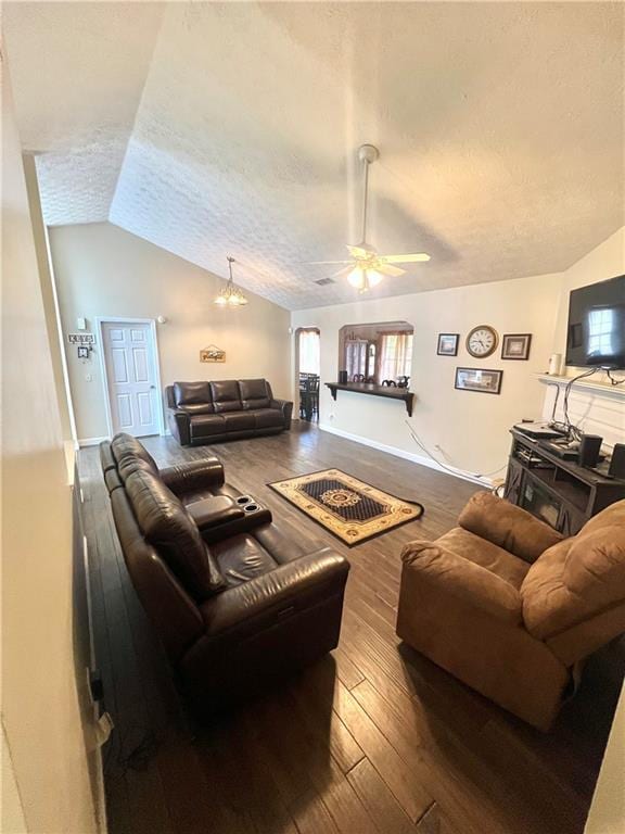 living area with a wealth of natural light, lofted ceiling, a textured ceiling, and hardwood / wood-style flooring