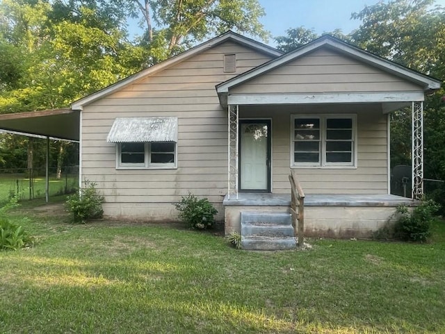 bungalow-style home featuring a carport, covered porch, and a front lawn