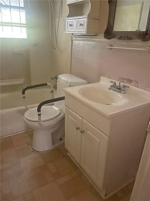 full bathroom with vanity, toilet, tile walls, and shower / bathing tub combination