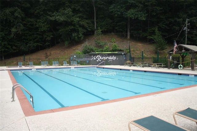 pool with a patio area and fence