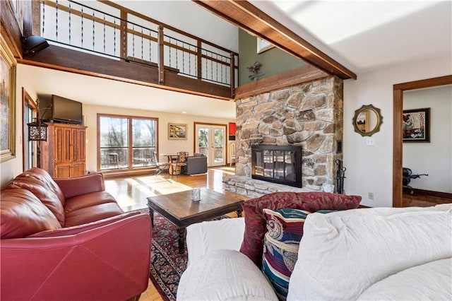 8145 Stone Hill Rd, Cumming, GA 30028 - living room with wood finished floors, a stone fireplace, beam ceiling, and a towering ceiling