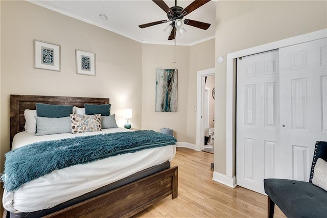 bedroom featuring baseboards, ornamental molding, light wood-style floors, a closet, and a ceiling fan