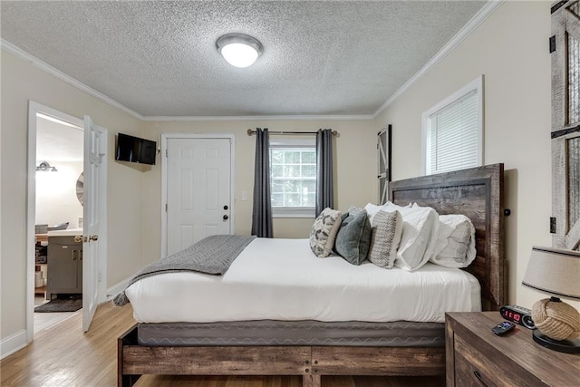 bedroom with baseboards, a textured ceiling, light wood-style floors, and ornamental molding