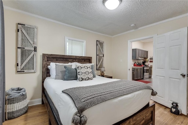 bedroom with a textured ceiling, light wood finished floors, and ornamental molding