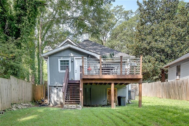 rear view of house featuring stairway, roof with shingles, a wooden deck, a yard, and a fenced backyard