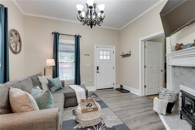 living area featuring an inviting chandelier, crown molding, light wood finished floors, and a textured ceiling