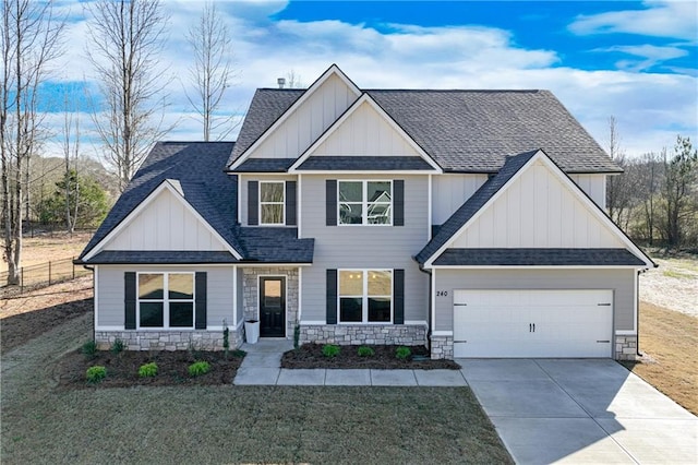 view of front of property featuring board and batten siding, concrete driveway, an attached garage, and stone siding