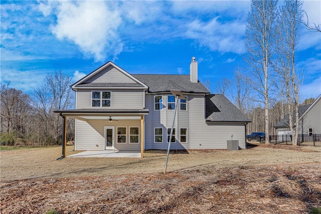 rear view of property featuring fence, cooling unit, a chimney, a patio area, and a ceiling fan