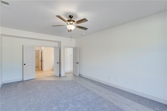 unfurnished bedroom featuring ceiling fan, light colored carpet, visible vents, and baseboards