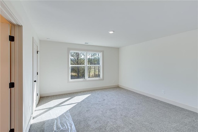 unfurnished room with light colored carpet and baseboards