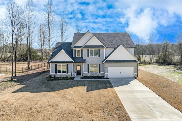 view of front of property featuring concrete driveway, board and batten siding, roof with shingles, and a front lawn