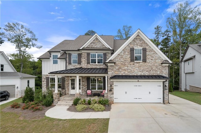 craftsman-style home featuring board and batten siding, a porch, driveway, and a standing seam roof