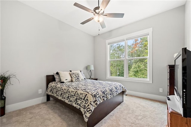 carpeted bedroom with baseboards, multiple windows, and a ceiling fan