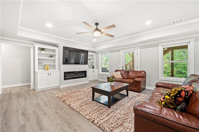 living room featuring crown molding, plenty of natural light, ceiling fan, and light wood-type flooring