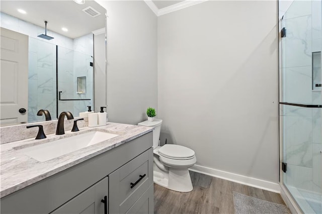 full bath with visible vents, a shower stall, toilet, ornamental molding, and wood finished floors