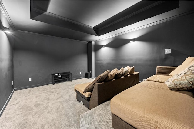 carpeted home theater featuring a tray ceiling, crown molding, and baseboards