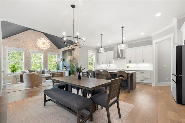 dining room featuring ornamental molding, sink, and light wood-type flooring