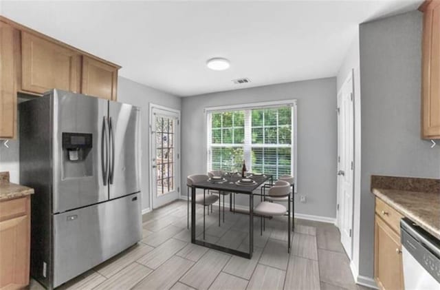 kitchen with dark stone countertops and appliances with stainless steel finishes