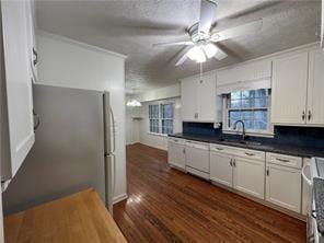 kitchen featuring dark hardwood / wood-style flooring, white cabinets, sink, and dishwasher