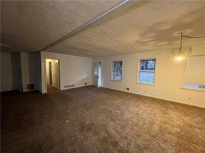 unfurnished living room featuring dark carpet