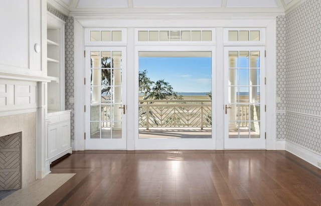 doorway featuring built in shelves, a healthy amount of sunlight, dark hardwood / wood-style floors, and ornamental molding