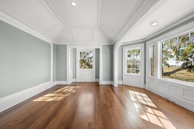 interior space with crown molding, lofted ceiling, and hardwood / wood-style flooring