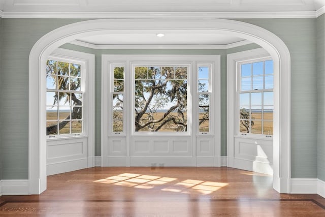 doorway with plenty of natural light, dark hardwood / wood-style flooring, and crown molding