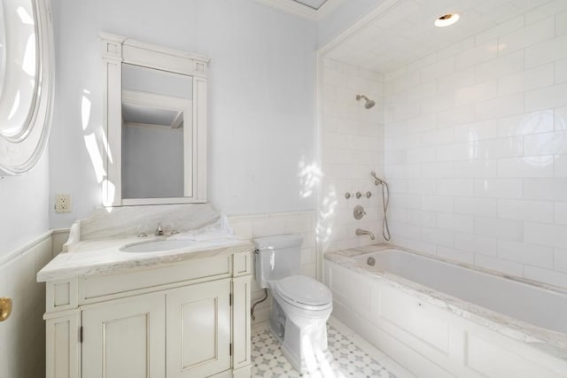 full bathroom featuring toilet, vanity, tiled shower / bath combo, and ornamental molding