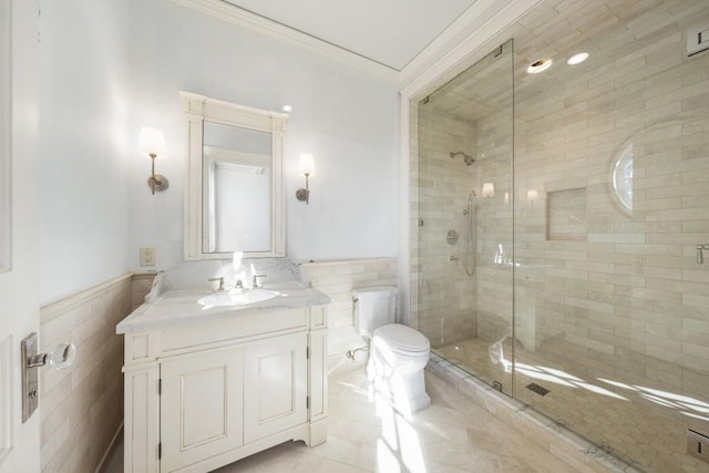 bathroom with vanity, toilet, ornamental molding, tile walls, and walk in shower