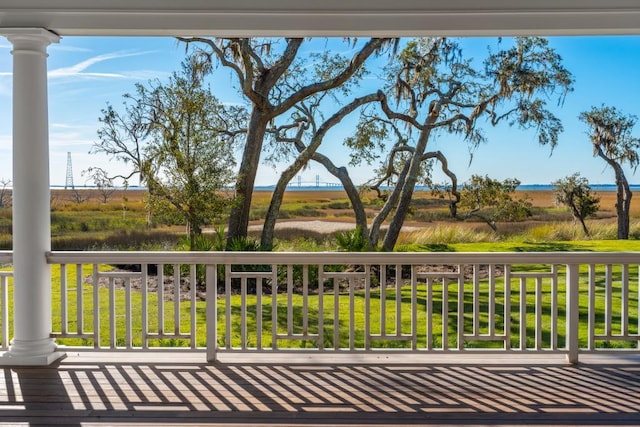 wooden deck featuring a rural view and a yard