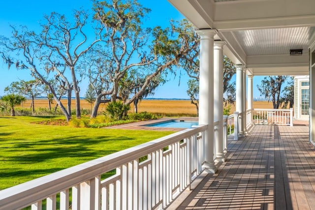 deck featuring covered porch and a lawn