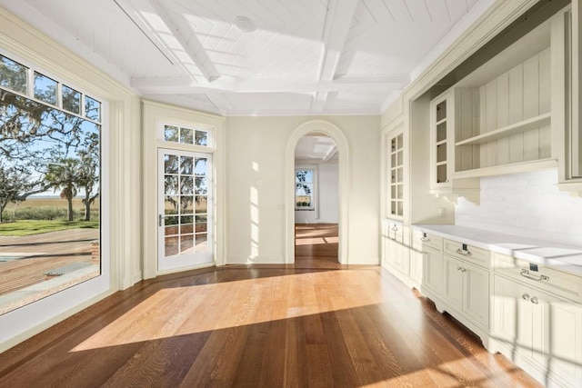 interior space with dark hardwood / wood-style flooring and beamed ceiling